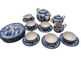 a blue and white tea set on a white table