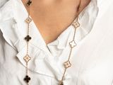the woman is wearing a white shirt and a gold chain necklace