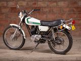 a white motorcycle parked in front of a brick wall