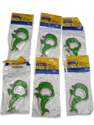 quatre aimants en plastique verts en forme de dauphin, présentés dans des sachets sur fond blanc