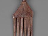 a wooden comb that is on a gray surface