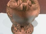 a bronze vase on display on a white table