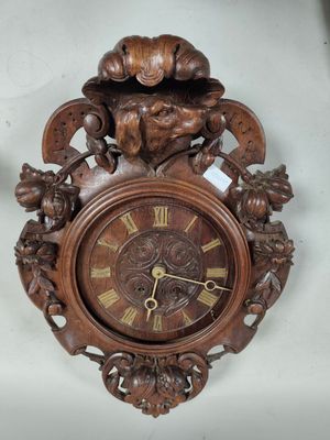 a clock that is hanging on the wall next to a vase