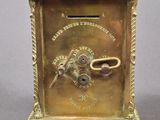 an antique brass clock with a key in the middle of it