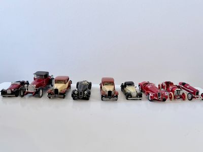 plusieurs petites voitures sont alignées sur une surface blanche