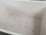 a white box with holes in it sitting on the floor