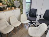 quatre chaises dans une pièce, avec un ventilateur en arrière-plan