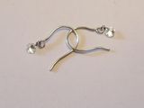 boucles d'oreilles plaquées argent ornées de cristaux transparents sur un fond blanc