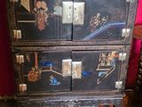 une commode noire ornée d'une peinture