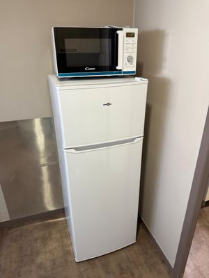 un réfrigérateur blanc surmonté d'un micro-ondes