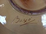 a brown vase with writing on it sitting on a table
