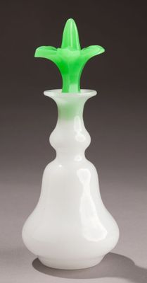 un vase blanc contenant une fleur verte