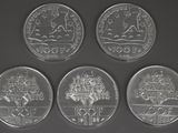 four different types of coins are shown on a black surface