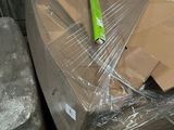 many boxes and boxes wrapped in plastic on the floor