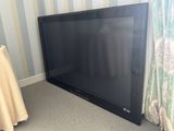 a flat screen tv sitting on the floor in the corner of a room