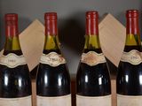 four bottles of wine are lined up in a row on a table