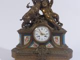 une horloge surmontée d'une statue, posée sur une table