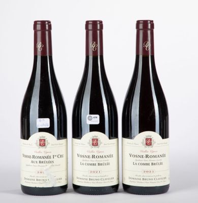 trois bouteilles de vin rouge sont alignées sur une surface blanche