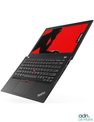 un ordinateur portable avec un écran rouge et un clavier noir posé sur une surface blanche