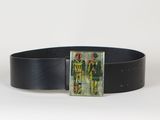 La ceinture est en cuir noir et comporte une boucle métallique sur laquelle figure l'image d'un homme vêtu de vert