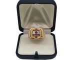 a close up of a ring in a box on a white surface