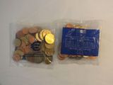 two bags filled with coins sitting on top of a white table