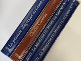 trois livres sont empilés sur une table