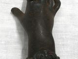a statue of a hand holding something in it ' s right hand