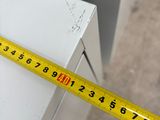 a measuring tape that is on the side of a cabinet