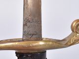 a close up of a gold colored sword with writing on it