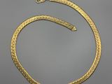 une image représentant un collier en or orné d'un serpent