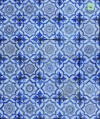 un gros plan sur un mur carrelé de bleu et blanc, composé de carreaux bleus et blancs