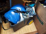 une boîte remplie d'outils et un casque de chantier posés par terre