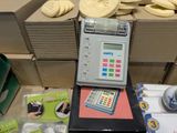 a cash register sitting on top of a table next to a pile of bananas