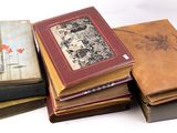 de nombreux livres empilés les uns sur les autres sur une surface blanche