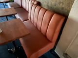 a table with a glass of wine on it in the corner of a restaurant