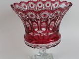 a red glass bowl on a clear stand