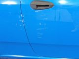 a close up of a blue car door with a sticker on it