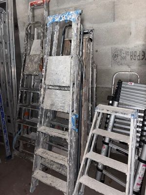 plusieurs échelles sont alignées contre un mur dans une pièce