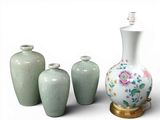 quatre vases posés les uns à côté des autres sur une surface blanche