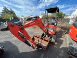 une petite pelleteuse garée sur le parking