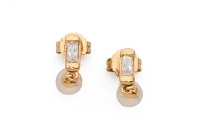 une paire de boucles d'oreilles en perles et en or sur fond blanc