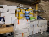 boxes of paint are stacked on top of each other in a garage