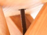 a screw that is stuck into a wooden chair