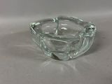 a clear glass ashtray with a silver handle
