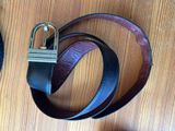 a belt with a padlock attached to it on a wooden surface