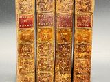 three old books are stacked on top of each other on a table