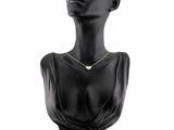a black mannequin head with a gold necklace on a white background