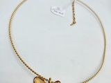 a close up of a necklace with a butterfly on it
