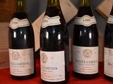 four bottles of wine are lined up on a red table